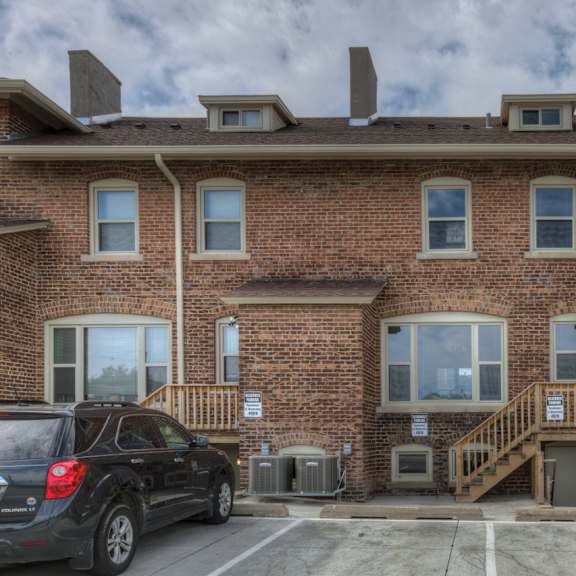 a brick building with a parking lot in front.