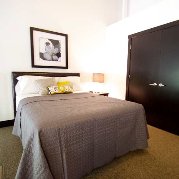 a bedroom with a bed, a picture frame, and a wardrobe.