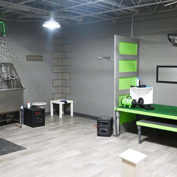 a room with a green bench and a grey wall.