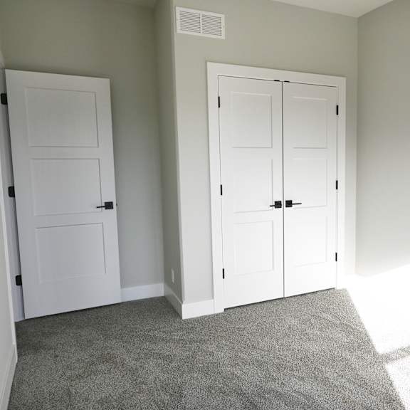a room with two white doors and a carpeted floor.