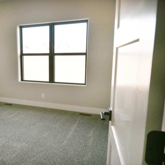 a room with a carpeted floor and a window.