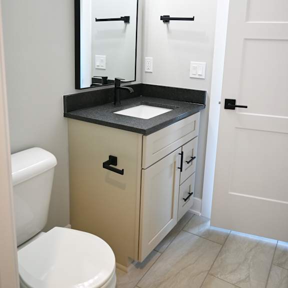 a bathroom with a toilet, sink, and mirror.
