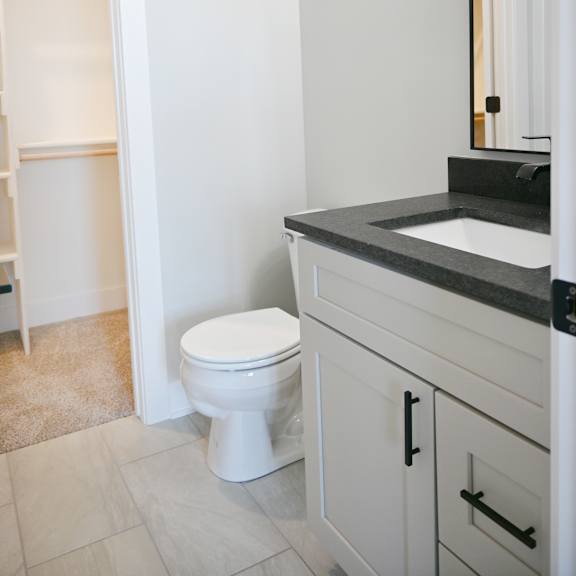 a white toilet sits in a bathroom next to a sink.