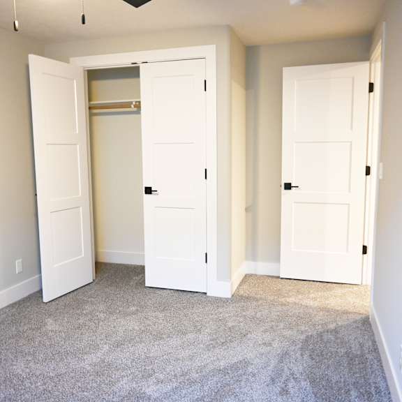 a room with two white doors and a carpeted floor.