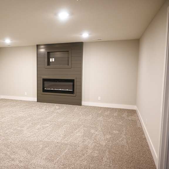 a room with a fireplace and carpeted floor.