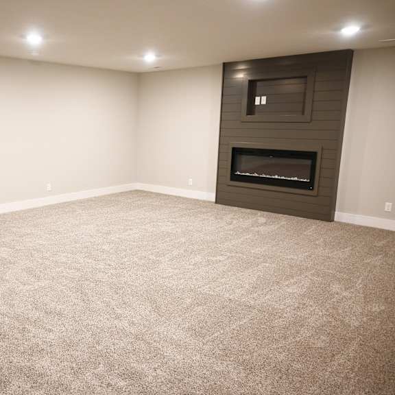 a room with a carpeted floor and a fireplace.