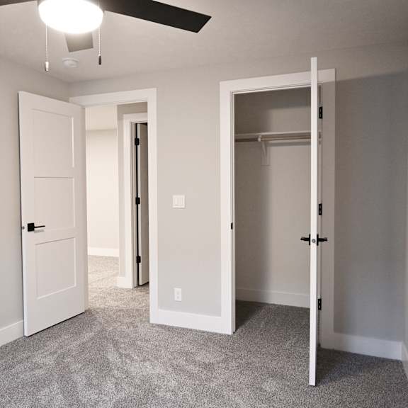 a room with a ceiling fan and two doors.