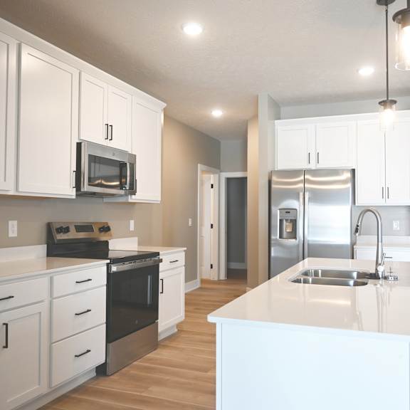 a kitchen with white cabinets and a white island.