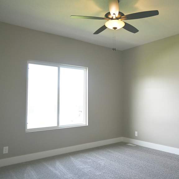 a room with a ceiling fan and a window.