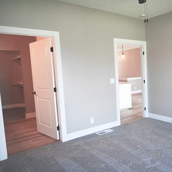 a room with a carpeted floor and two open doors.