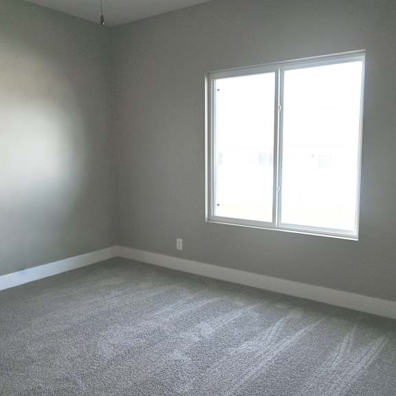 a room with a carpeted floor and a window.