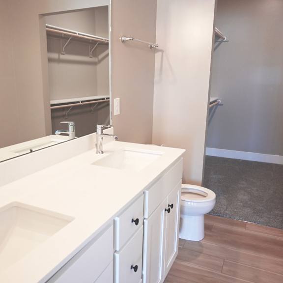a white bathroom with a sink, toilet, and mirror.