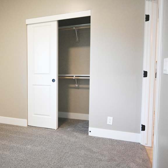 a room with a white door and a grey carpet.