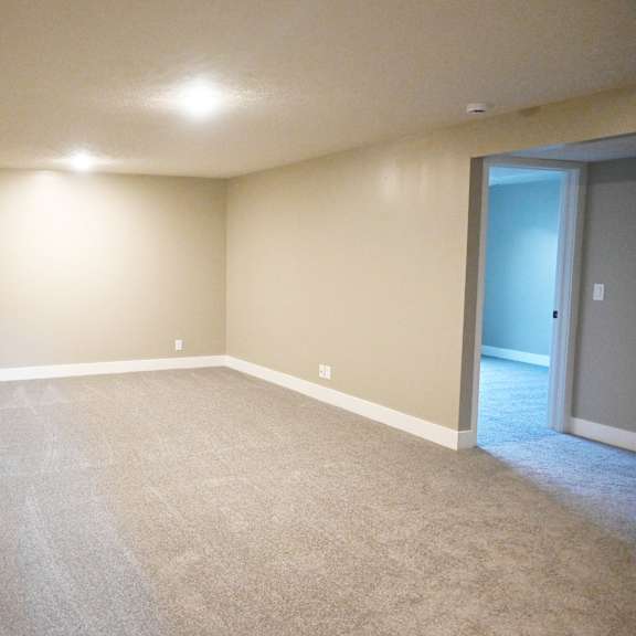 a room with a carpeted floor and a door on the right side.