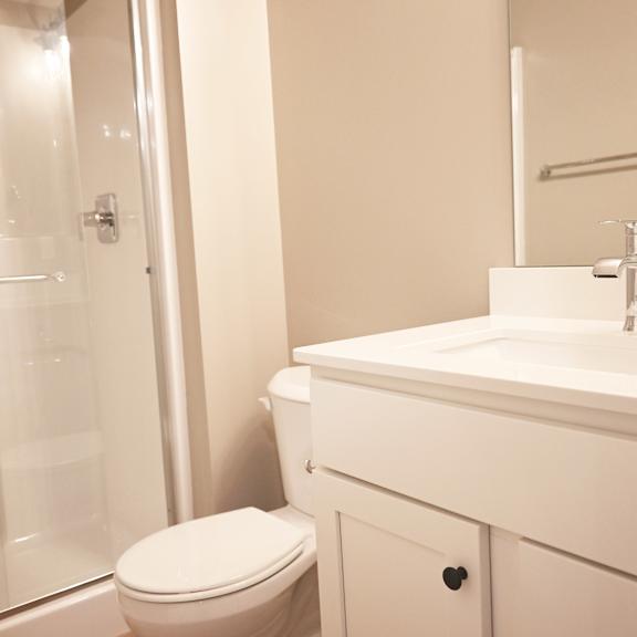 a white toilet sits next to a sink in a bathroom.