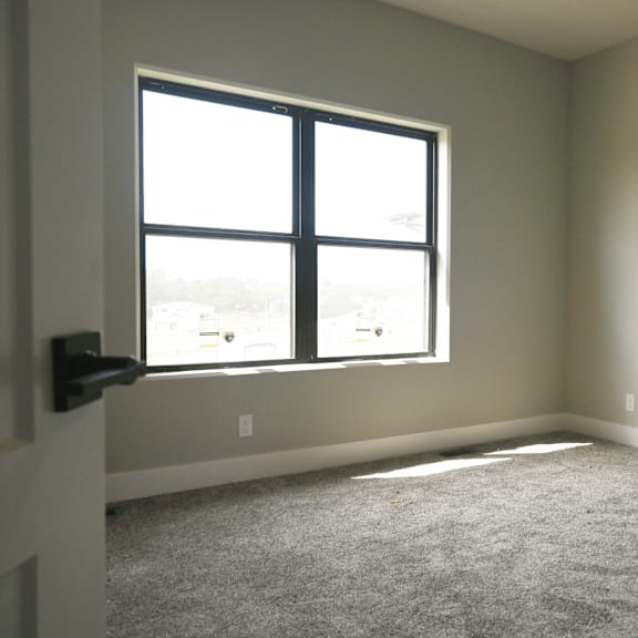 a room with a carpeted floor and a large window.