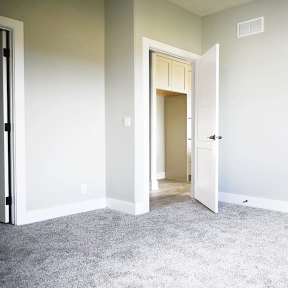 a room with a carpeted floor and a doorway leading to another room.