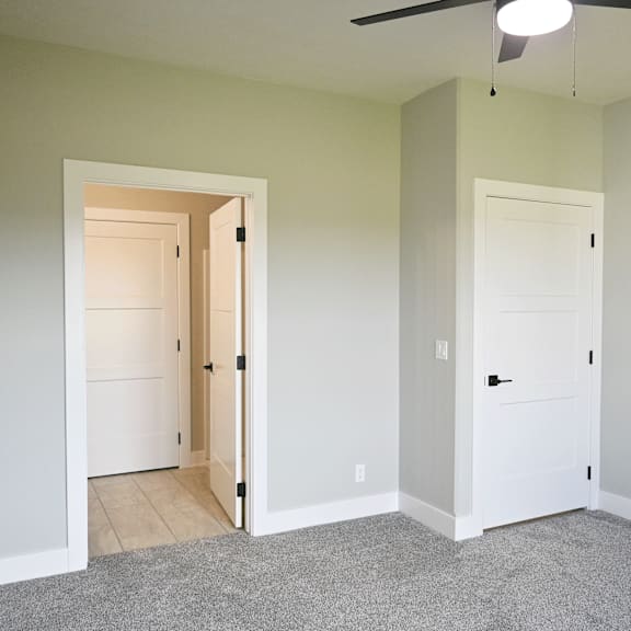 a room with a ceiling fan and two doors.