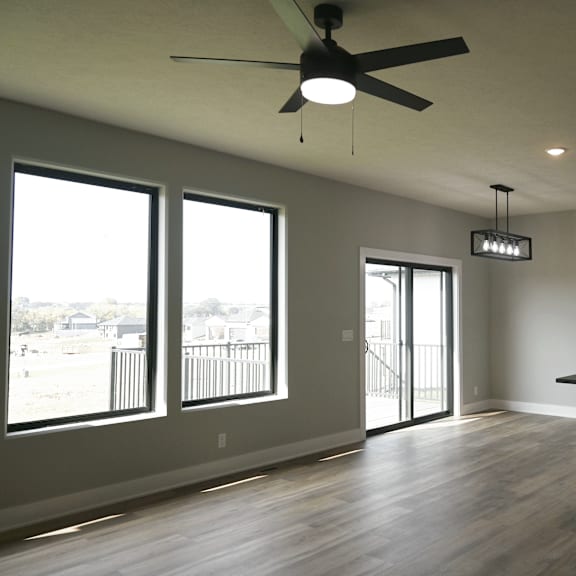 a room with a ceiling fan and a kitchen island.