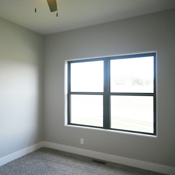 a room with a window and a carpeted floor.