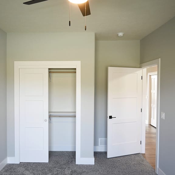 a room with a ceiling fan and two doors.