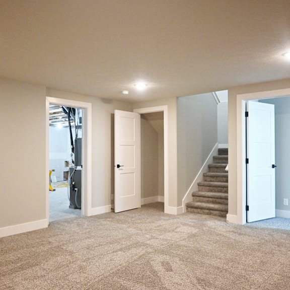 a spacious room with carpeted floor and white walls.