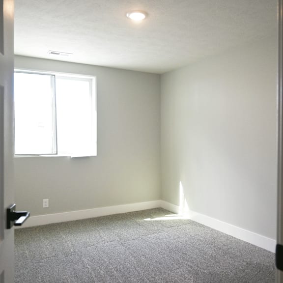 a room with a carpeted floor and a window.