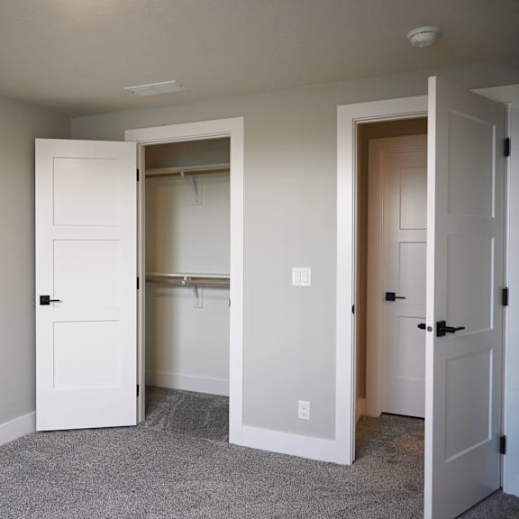 a room with a white door and a grey carpet.