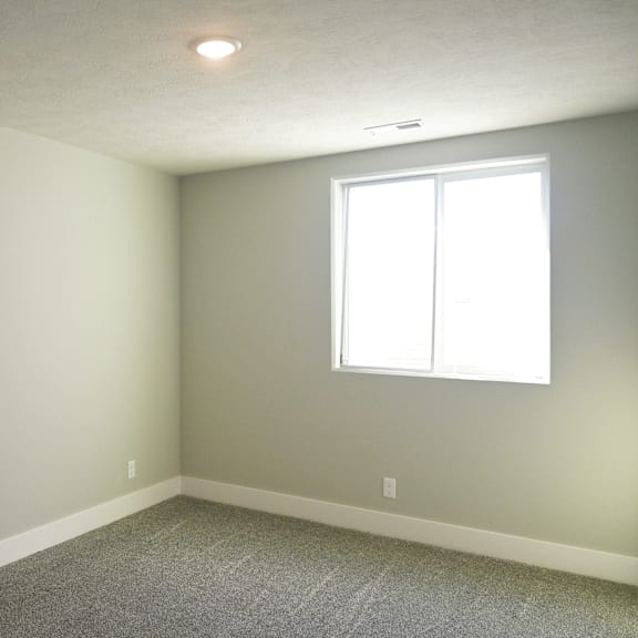 a room with a window and carpeted floor.