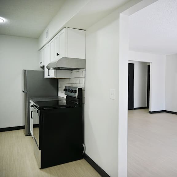 a kitchen with black appliances and white cabinets.