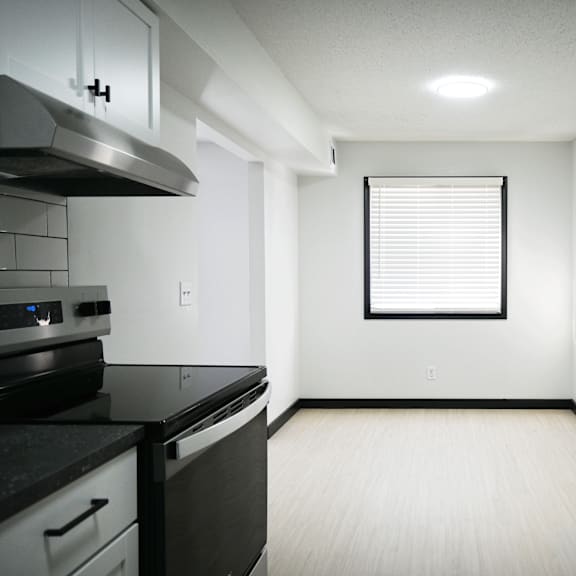 a kitchen with black countertops and white cabinets.