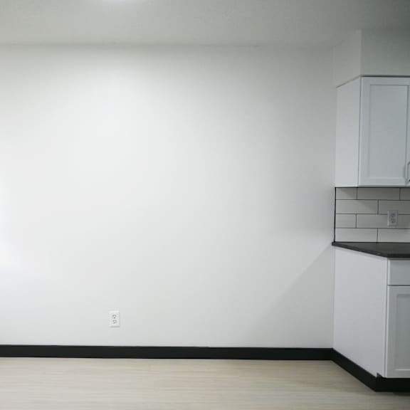 a white room with a window and a cabinet.