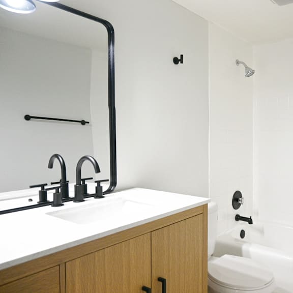 a white bathroom with a sink and a bathtub.