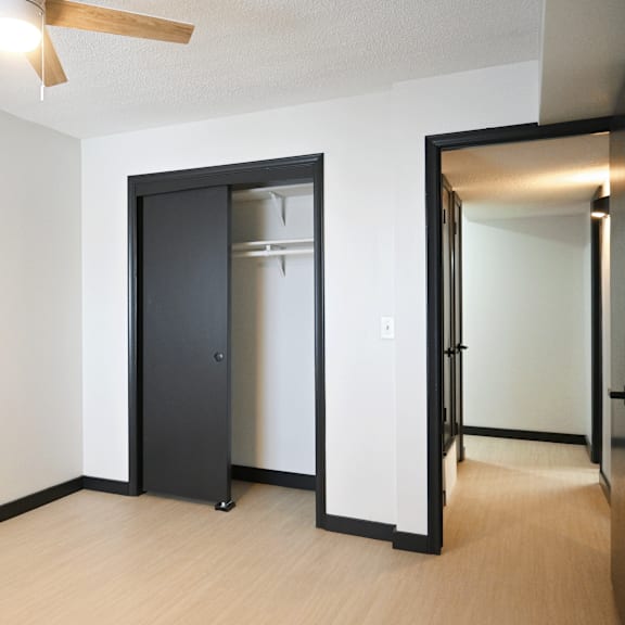 a room with a ceiling fan and a black door.