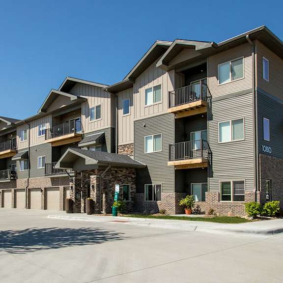 apartment complex with a parking lot in front.