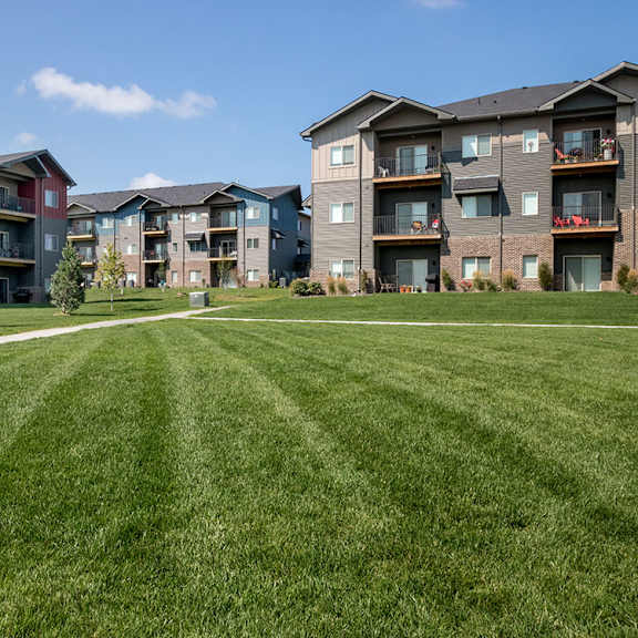 apartment buildings with green lawns in front.