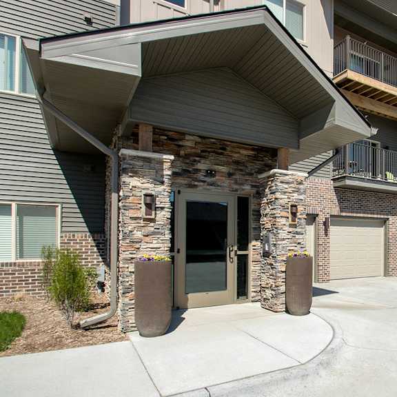 a modern apartment building with a stone pillar entrance.
