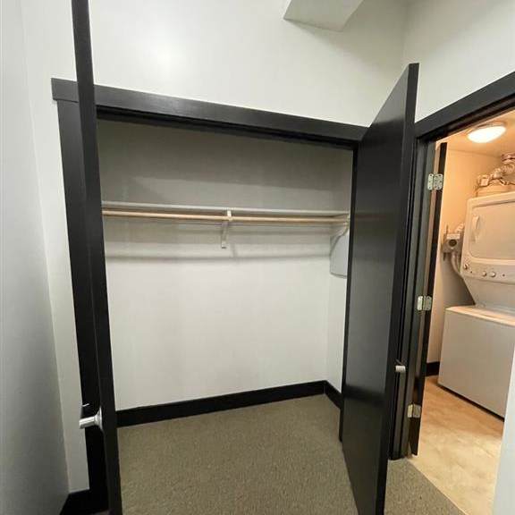 a black closet with a white door is open.