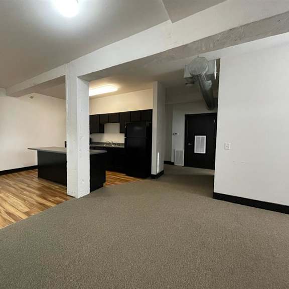 a room with a grey carpet and a wooden floor.
