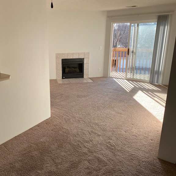 a living room with a fireplace and sliding glass doors.