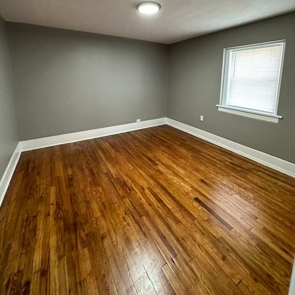 a room with wooden flooring and a window.