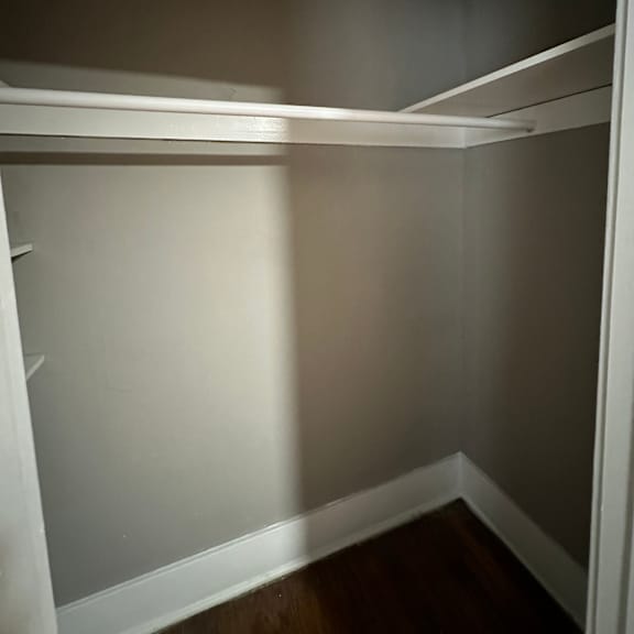 a white closet with shelves and a white door.