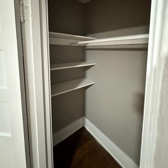 a white refrigerator with its door open and empty shelves.