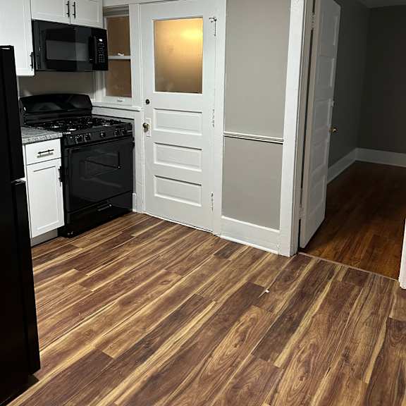 a kitchen with a black fridge and stove top oven.