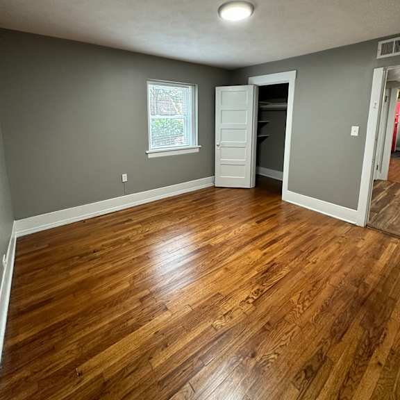 a room with wooden flooring and a window.