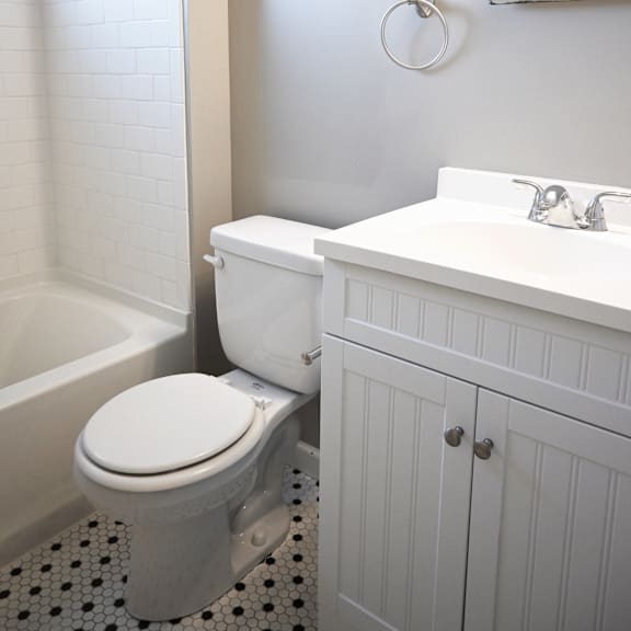 a white toilet sits in a bathroom next to a sink.