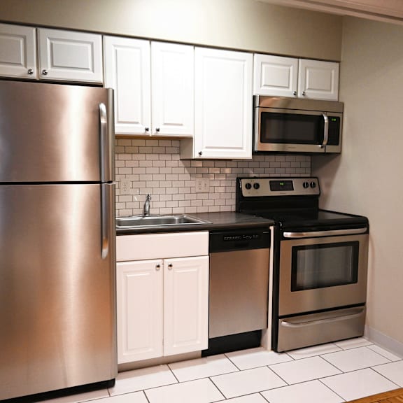 a kitchen with a stainless steel refrigerator, microwave, oven, and dishwasher.