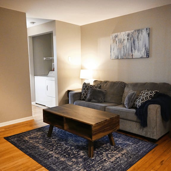a living room with a grey couch and a wooden coffee table.
