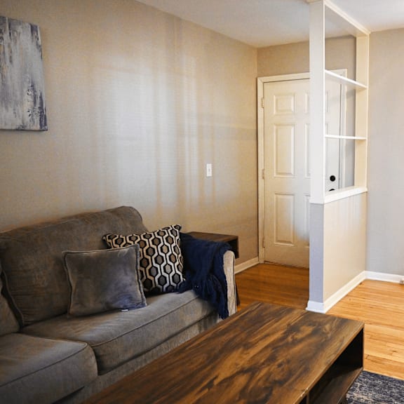 a living room with a grey couch and a wooden coffee table.