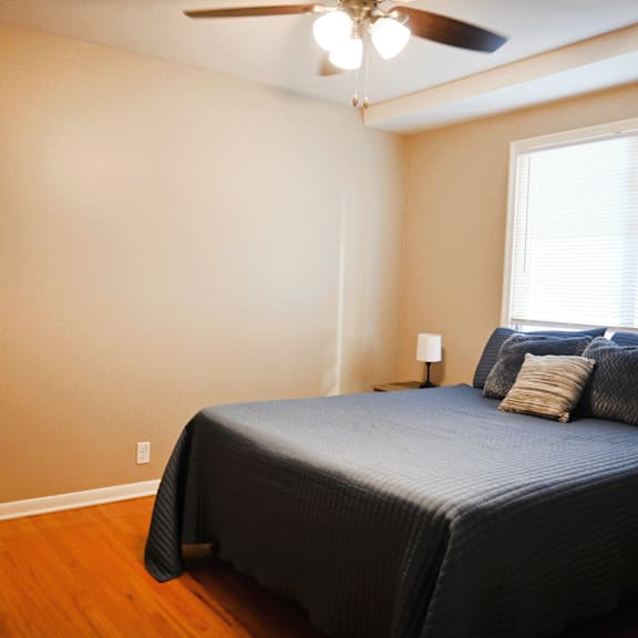 a bedroom with a bed, pillows, and a ceiling fan.